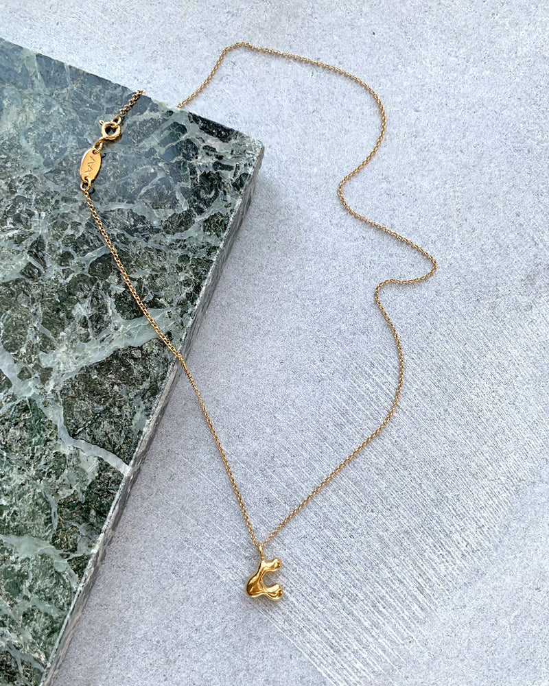 Die Bet Halskette Gold ist eine dreidimensionale Form die an organische Formen und Skulpturen erinnern. Die Halskette ist aus Sterlingsilber gefertigt und mit einer 2 Mikron Schicht aus Gold überzogen. Die vergoldete Kette wurde von Hand gefertigt und ist 46 cm lang.