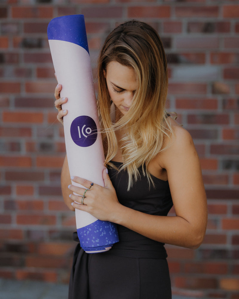 Die Cosmic Girl Yogamatte hat ein kosmisches Design mit der Gestalt einer Frau die sich am Mond festhält. Es dominieren die Farben beige und blau/ violett. Diese Sportmatte ist aus Naturkautschuk nachhaltig und vegan hergestellt. Sie ist rutschfest und zeichnet sich durch ihr einzigartiges Design aus. Größe: 183 x 61 cm Dicke: 2,5 - 3 mm Gewicht: 1,9 - 2,4 kg Inklusive: Tragegurt