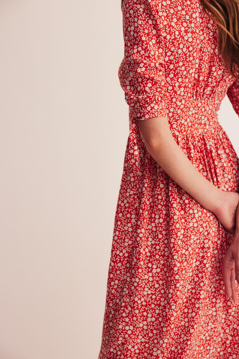 Sophie Italian Summer Kleid besteht aus nachhaltiger Viskose hat Dreiviertel Ärmel, ist mit einem Blumendruck in rot weiß versehen und ist ein maxi Kleid. In den Größen S/M/L